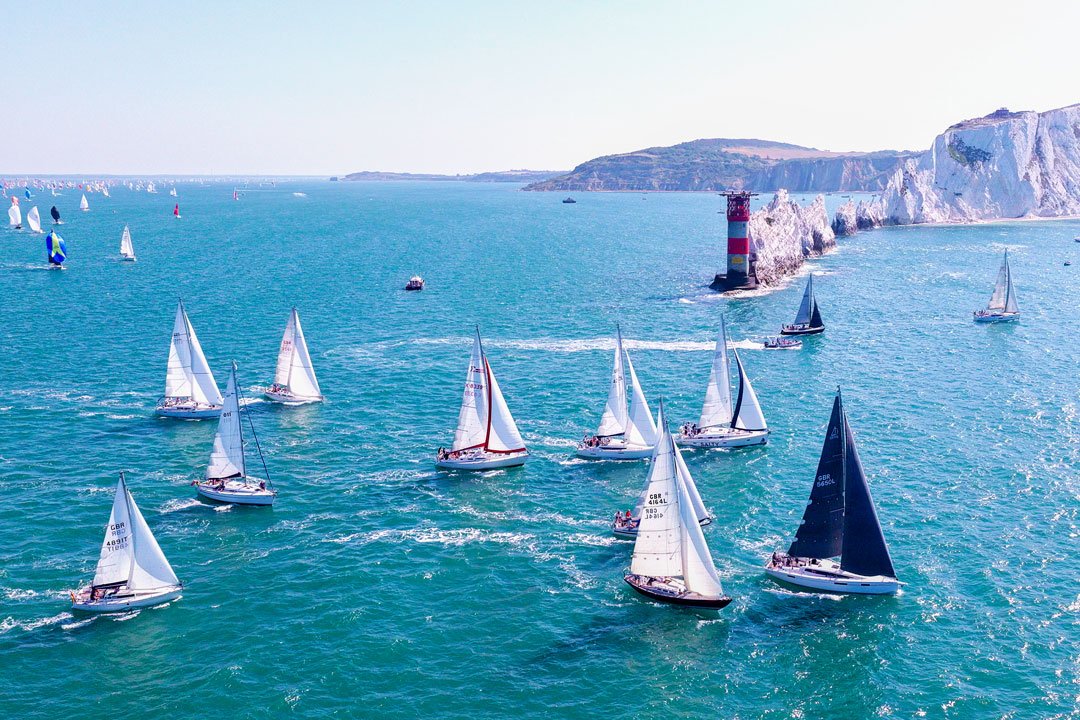 Round the Island Race 2026 yachts passing The Needles Lighthouse on the Isle of Wight captured from an aerial drone.